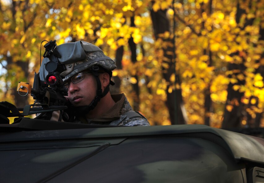 U.S. Air Force Staff Sgt. Joseph Weidenbach, 823rd Base Defense Squadron fire team leader, looks through his scope for insurgents after a convoy was attacked by a roadside improvised explosive device during an exercise at Camp Smith, N.Y., Oct. 28, 2011. Weidenbach returned fire during a small fire fight and continued to provide security during a medical evacuation. (U.S. Air Force photo by Staff Sgt. Stephanie Mancha/Released)
