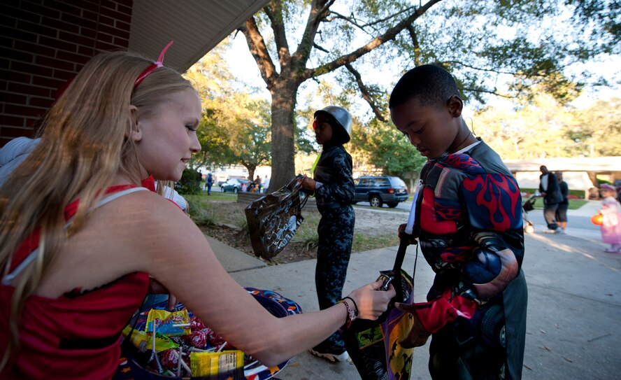 Chance and Noah Minor receive candy from Emily Strange during trick or treat at Moody Air Force Base, Ga., Oct. 29, 2011. Chance and Noah are sons of U.S. Air Force Staff Sgt. Robert Minor of the 23rd Operations Support Squadron. Emily is the daughter of Master Sgt. Scott Strange of the 23rd Equipment Maintenance Squadron. (U.S. Air Force photo by Staff Sgt. Jamal D. Sutter/Released)