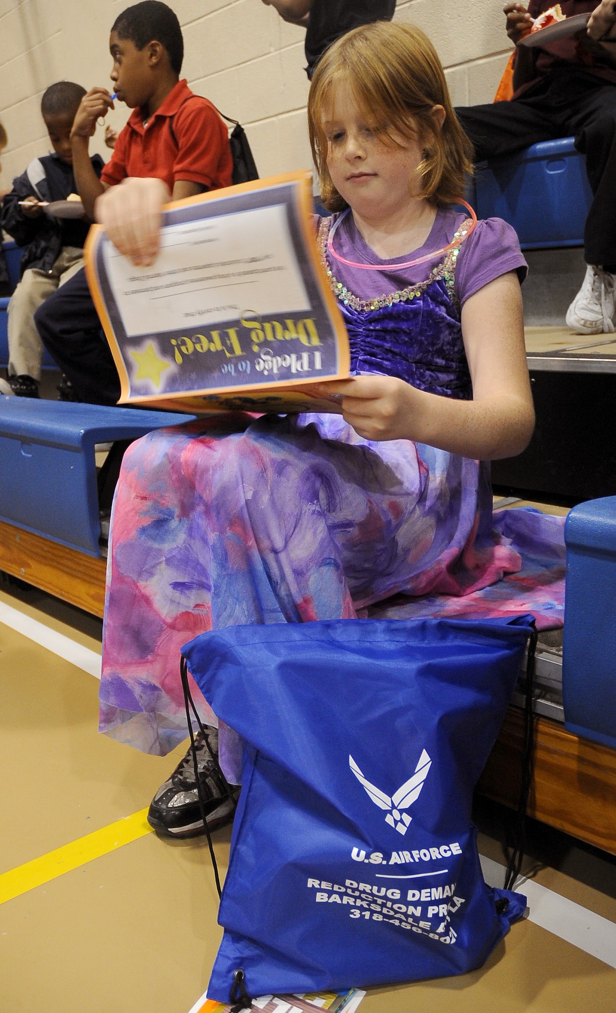 A child views a booklet about being drug free at the Red Ribbon Week pledge event on Barksdale Air Force Base, La., Oct. 27. The pledge was the last event held for Red Ribbon Week here. More than 50 children were joined by Col. Thomas Hesterman, 2nd Bomb Wing vice commander, Chief Master Sgt. Larry Malcom, 2 BW command chief, Sparky the fire mascot and McGruff the crime fighting dog, to take the drug-free pledge. (U.S. Air Force photo/Senior Airman Amber Ashcraft)(RELEASED)