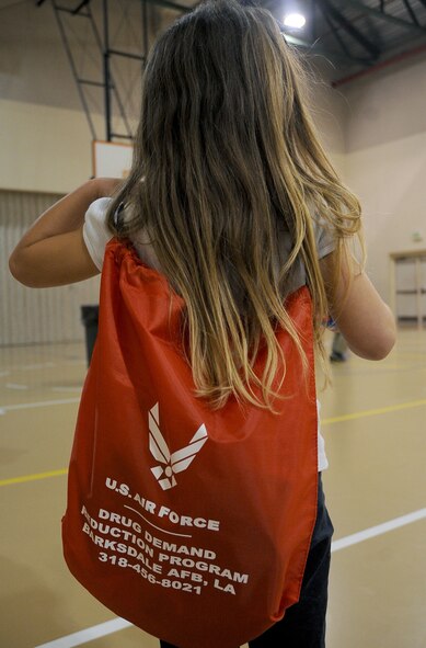 A child adjusts a back-pack given to her for signing a drug-free pledge on Barksdale Air Force Base, La., Oct. 27. The pledge was the last event held for Red Ribbon Week here. More than 50 children were joined by Col. Thomas Hesterman, 2nd Bomb Wing vice commander, Chief Master Sgt. Larry Malcom, 2 BW command chief, Sparky the fire mascot and McGruff the crime fighting dog, to take the drug-free pledge. (U.S. Air Force photo/Senior Airman Amber Ashcraft)(RELEASED)