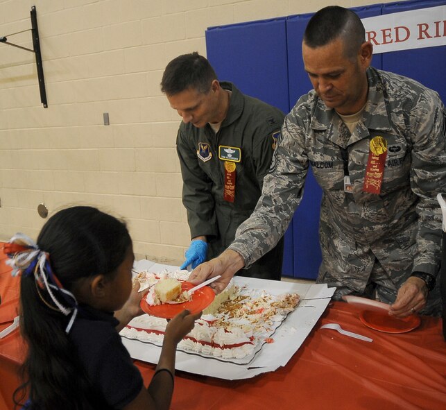 Col. Thomas Hesterman, 2nd Bomb Wing vice commander, and Chief Master Sgt. Larry Malcom, 2 BW command chief, serve cake to children after the Red Ribbon Week pledge event on Barksdale Air Force Base, La., Oct. 27. The pledge signing was the last event held for Red Ribbon Week to bring awareness about drugs to Barksdale families. More than 50 children attended the event and signed the pledge to be drug free. (U.S. Air Force photo/Senior Airman Amber Ashcraft)(RELEASED)