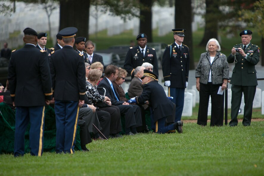 A Soldier presents an American flag to one of the Family members at the interment of ten Army Airmen Soldiers from World War II at Arlington National Cemetery on Oct. 26, 2011. The crew of ten Soldiers crashed in their B-24J Liberator aircraft while on a bombing mission over Germany on April 29, 1944. (U.S. Army photo by Rachel Larue)