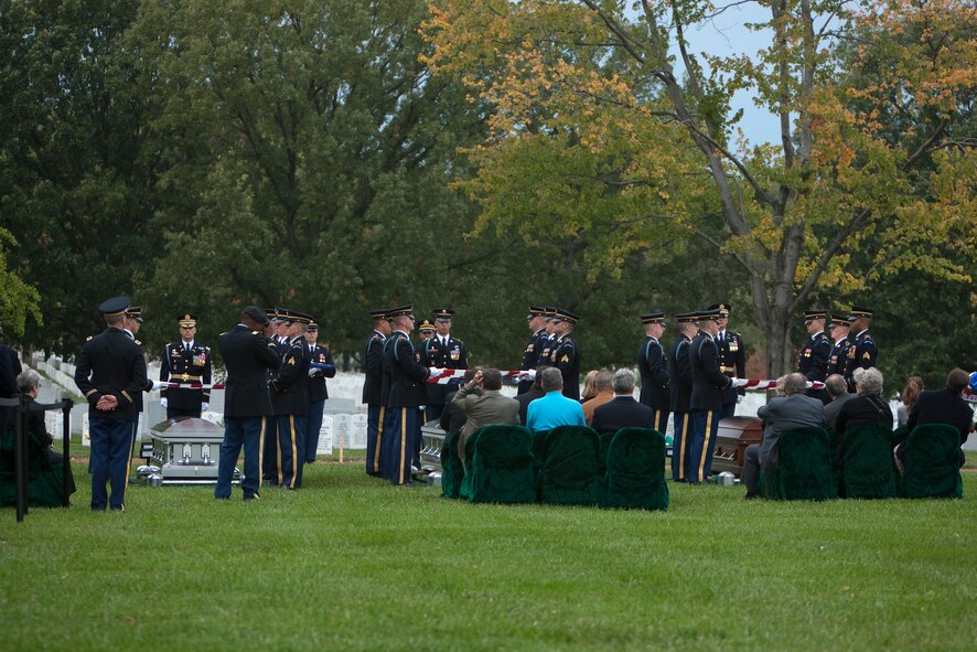 Members of the Casket Team fold American flags over caskets representing 10 Army Airmen soldiers from World War II in Arlington National Cemetery’s Section 60 on Oct. 26, 2011. The casket on the left represents the remains of 10 Army Airmen soldiers from World War II, the center casket represents the remains of Staff Sgt. Joseph J. Karaso, and the casket on the right represents the remains of 2nd Lt. Donald W. Hess. The crew of ten Soldiers crashed in their B-24J Liberator aircraft while on a bombing mission over Germany on April 29, 1944. (U.S. Army photo by Rachel Larue)