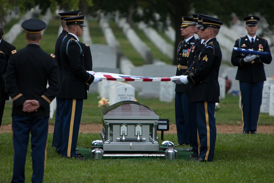 Members of the Casket Team fold the American flag over a casket representing the remains of 10 Army Airmen soldiers from World War II in Arlington National Cemetery’s Section 60 on Oct. 26, 2011. The crew of ten Soldiers crashed in their B-24J Liberator aircraft while on a bombing mission over Germany on April 29, 1944. (U.S. Army photo by Rachel Larue)