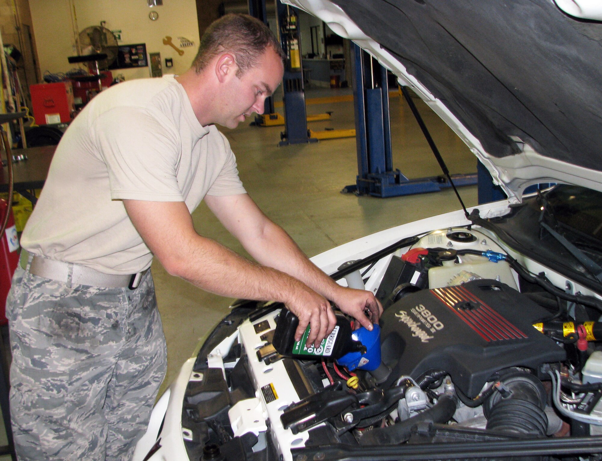 Tech Sgt. Dustin Hurlbut, 412th Maintenance Logistics Squadron, says he takes all three of his vehicles to the Edwards Auto Hobby Shop for routine maintenance. Hurlbut is changing the oil in his 2003 Grand Prix here, Oct. 26. He said he saves anywhere from $15 to $20 per vehicle each time he does an oil change and tire rotation at the hobby shop on base. (U.S. Air Force Photo by Diane Betzler) 