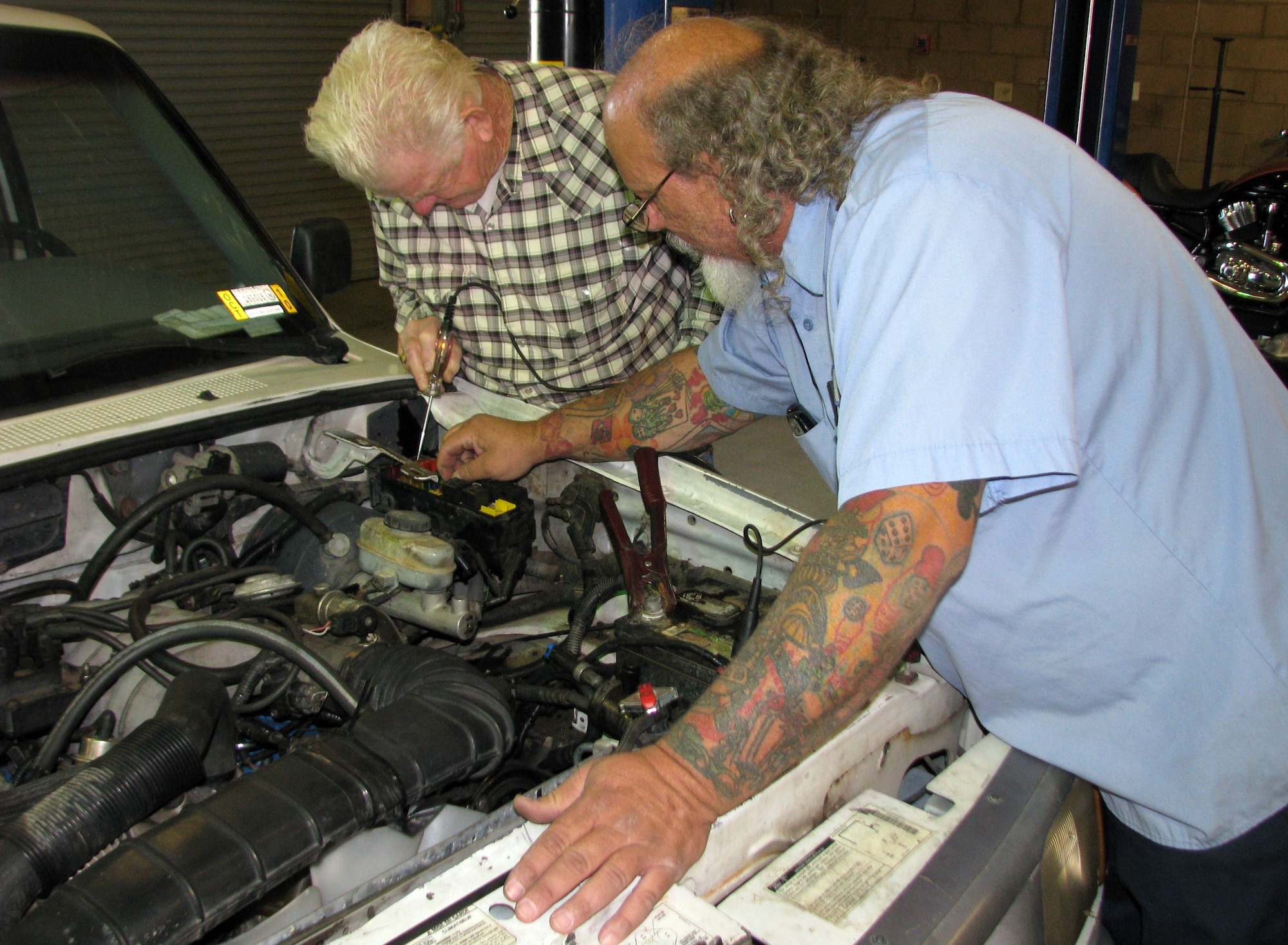 Jessie Mattox, Edwards Auto Hobby Shop supervisior, helps customer Dusty Rhodes, a retired NASA employee, troubleshoot a minor problem with the engine in Rhodes' 1995 Ford Ranger. (U.S. Air Force Photo by Diane Betzler) 