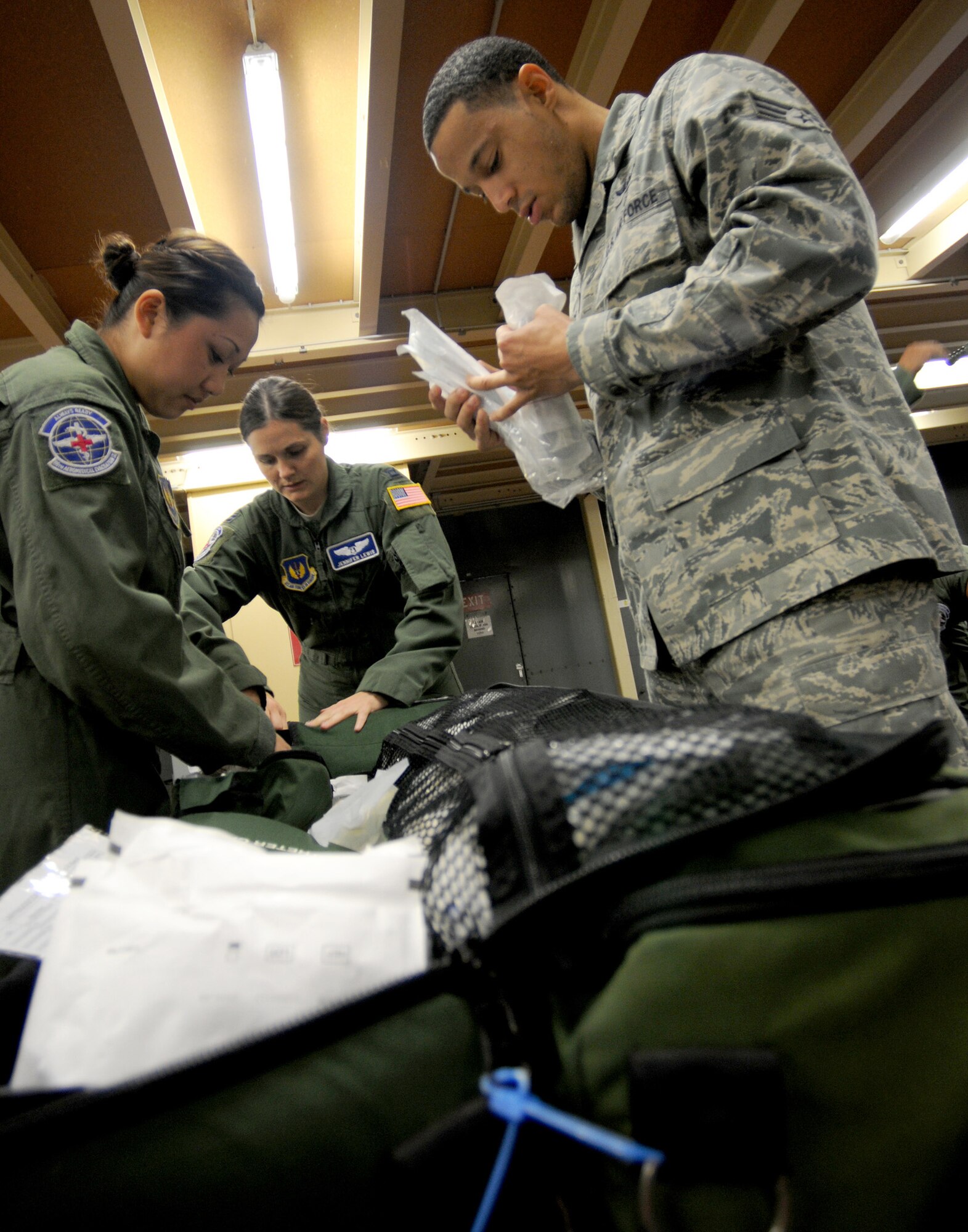 Tech. Sgt. Yayee Thayer (left) works with Capt. Capt. Jennifer Lewis (center) and Senior Airman Benjamin Pace at Ramstein Air Base, Germany, on Oct. 28, 2011, double checking medical supplies for a humanitarian assistance mission evacuating 26 injured freedom fighters from Tripoli, Libya.  Thayer and Pace are team members from the 86th Aeromedical Evacuation Squadron based at Ramstein. The two aircraft transported 26 seriously wounded fighters to Spaulding Rehabilitation Hospital in Boston, Mass. An additional four critical cases were transferred to Germany for immediate care. All patients were injured as a result of recent fighting and suffer from conditions that cannot currently be treated in Libya. (U.S. Army Photo/Pvt. Richard Bartell)