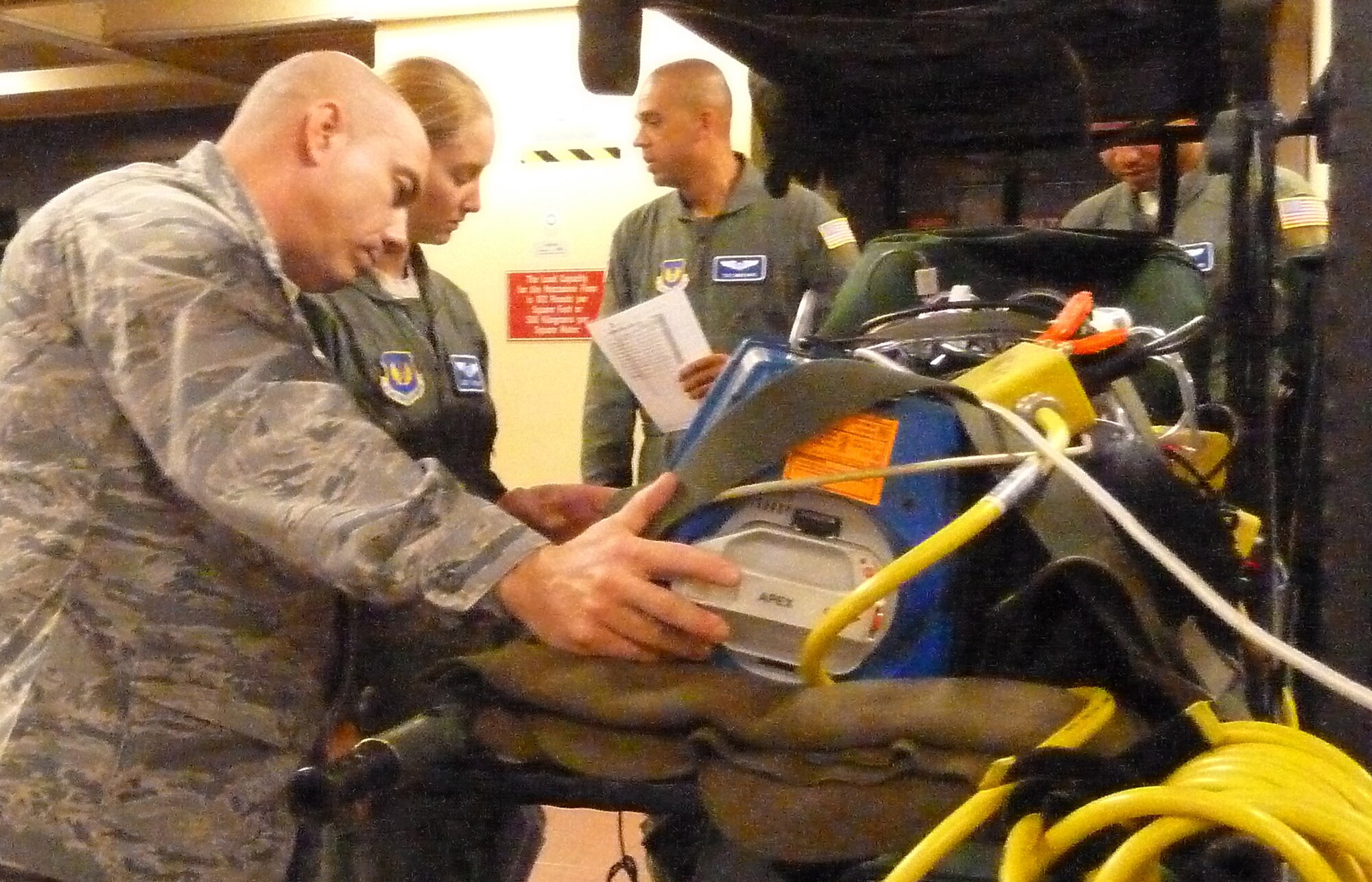 Maj. Pablo Snead (left) and Capt. Emily Jarding prepare a heart defibulator loading on to an aircraft at Ramstein Air Base, Germany, on Oct. 28, 2011. Snead and Jarding are team members from the 86th Aeromedical Evacuation Squadron at Ramstein who took part in a humanitarian assistance mission evacuating 26 injured freedom fighters from Tripoli, Libya. (U.S. Army Photo/Pvt. Richard Bartell)