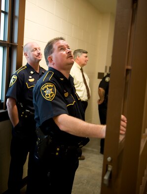 Local law enforcement officers look inside the jail cells of the new 2nd Security Forces Squadrons building on Barksdale Air Force Base, La., Oct. 27. The community police officers were invited by the 2 SFS to tour its new facility on base and share law enforcement ideas. (U.S. Air Force photo/Airman 1st Class Benjamin Gonsier)(RELEASED)