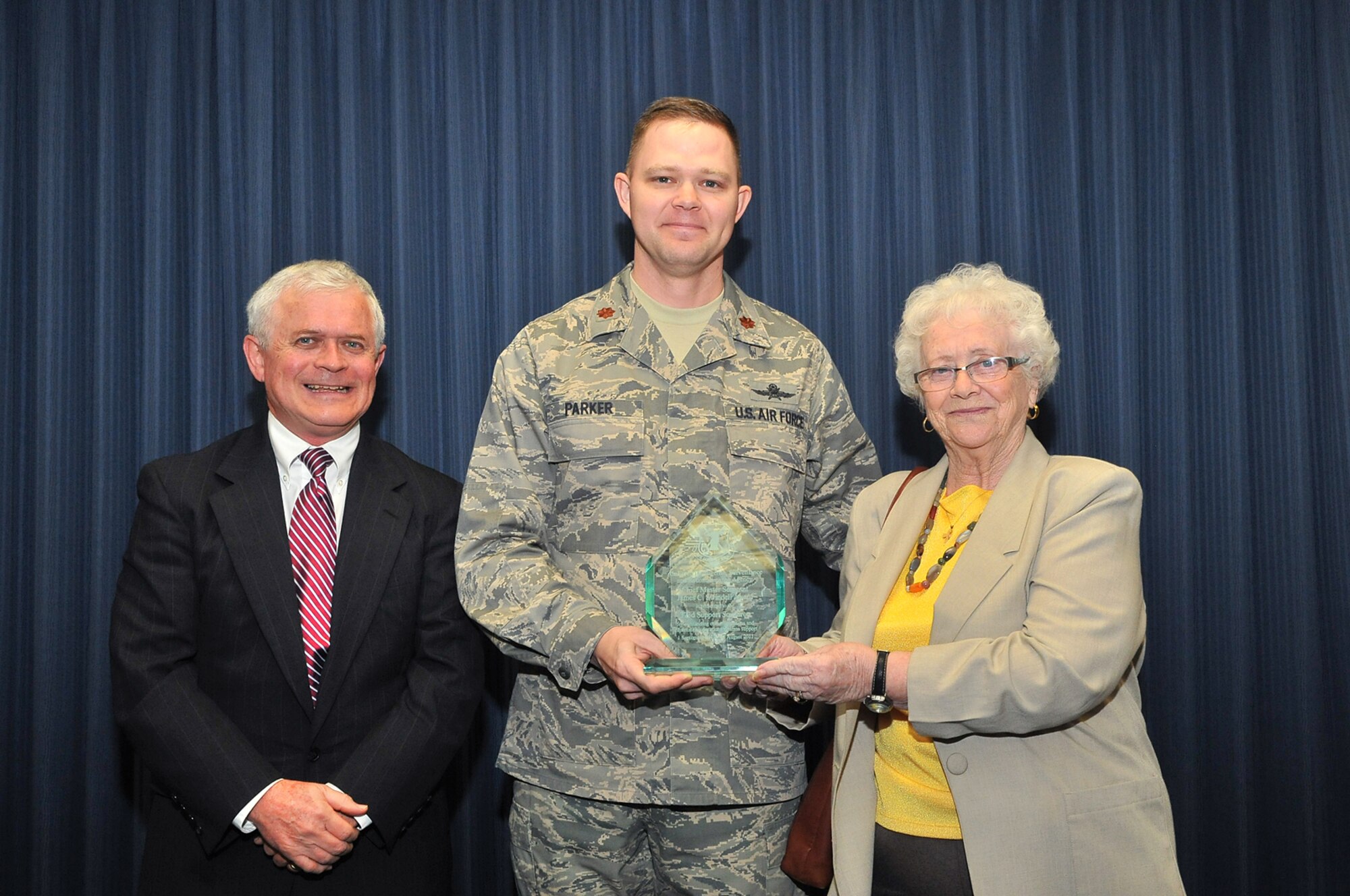 Maj. Robert Parker, 373rd Support Squadron commander, accepts the Chief Master Sergeant James C. Swindell Award Oct. 26 from the Chief's wife, June and her son Clay, for outstanding communication and information operations systems support. The 373rd is based at Misawa Air Base, Japan. The presentation highlighted the Air Force Intelligence, Surveillance and Reconnaissance Agency's annual Sensor Rally Commanders' Conference at Lackland Air Force Base, Texas. (Photo by William Belcher) 