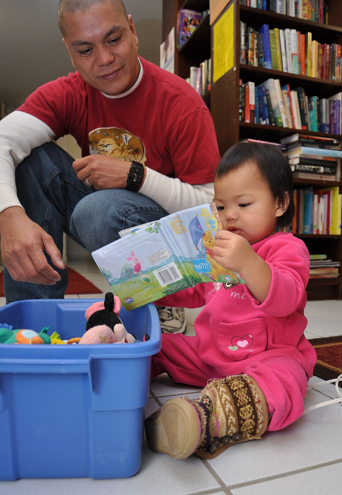 SPANGDAHLEM AIR BASE, Germany -- Tech. Sgt. Armando Penales, 726th Air Mobility Sqaudron, looks for a book with his daughter, Gloriany, at the Airmen’s Attic here Oct. 28. Penales and his family just moved from Hickam Air Force Base, Hawaii, and picked up items for their new home from. The Airmen’s Attic is available for all Airmen to pick up and donate household items. They are open Tuesday and Thursday from 10 a.m. – 2 p.m. and Wednesday from 1 – 6 p.m. to serve Saber Airmen and their families. (U.S. Air Force photo/Senior Airman Natasha E. Stannard)