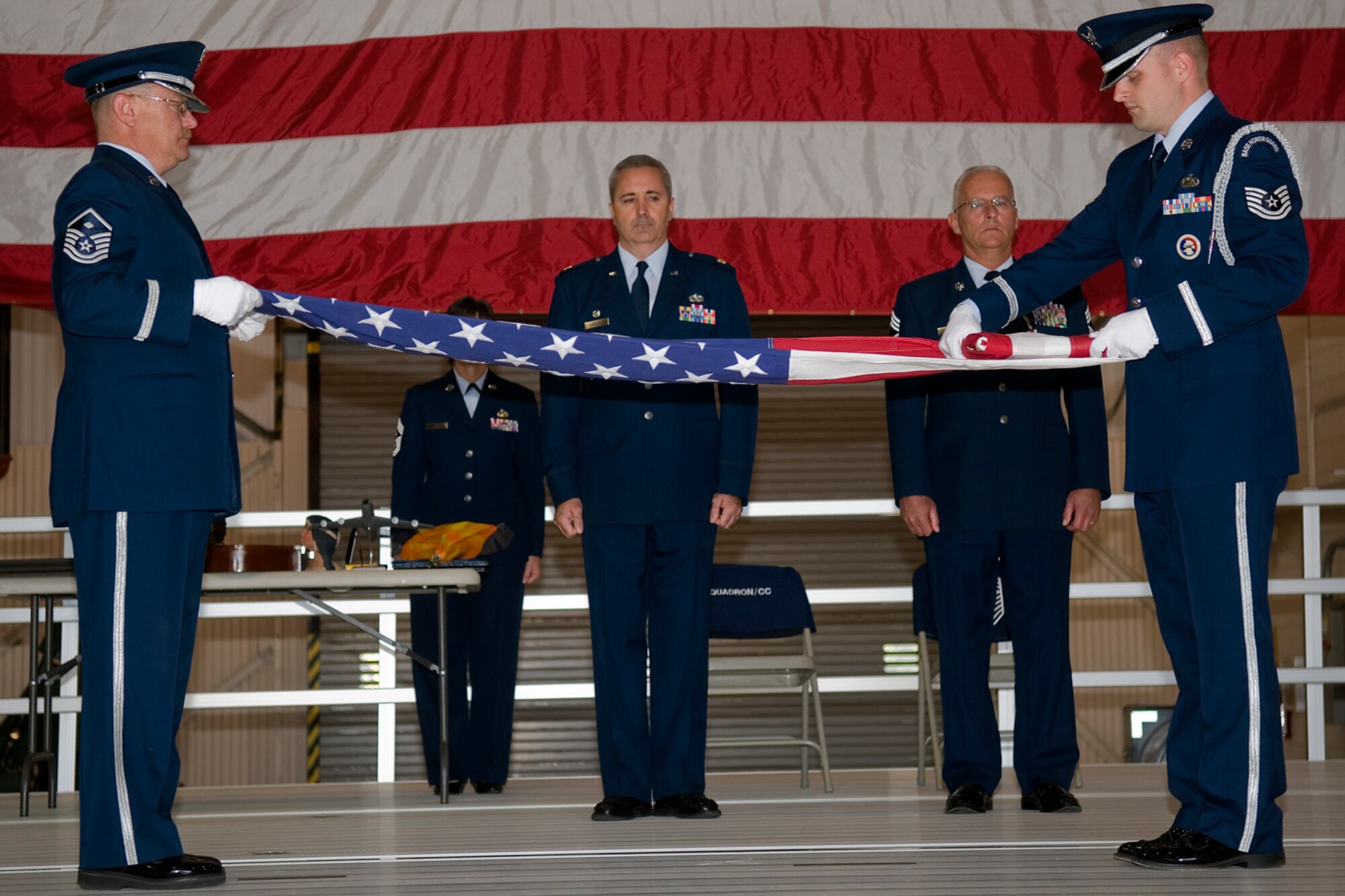 GRISSOM AIR RESERVE BASE, Ind. -- Tech. Sgt. Mark Orders-Woempner, Grissom Air Reserve Base Honor Guard, carefully folds the flag with Master Sgt. Geoffrey Spaulding during a retirement ceremony Oct. 15. Chief Master Sgt. Michael Fornal, 434th Aircraft Maintenance Squadron superintendant, retired after serving 34 years. Next to Fornal is Maj. Timothy Bartlett, 434th AMXS commander. (U.S. Air Force photo/Senior Airman Jami K. Lancette)