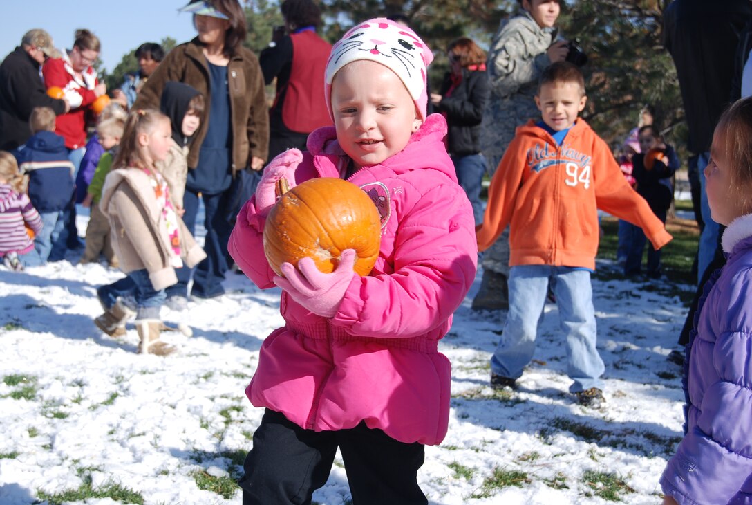 PETERSON AIR FORCE BASE, Colo. — Audrina Chavez, daughter of Laurie Chavez, Child Development Center care giver, picks a pumpkin from a pumpkin patch at Patriot Park, Oct. 28, 2011. Kids from the main CDC played in a hay stack maze and picked pumpkins to take home for Halloween 
The 21st Medical Group is having a community harvest festival from 7:30 a.m.-5 p.m. Oct. 31 at the clinic. The stroller-friendly event is for the whole family. Dress-up in your costumes and come learn about preventive health services while enjoying safe trick-or-treating for the kids, costumes, decorations and hay rides in a festive Halloween atmosphere. Trick or treating hours for Peterson AFB housing are 6:30-8:30 p.m. Oct. 31. Airmen from the 21st Security Forces Squadron and volunteers will be walking base housing, providing a safe trick-or-treating environment for the kids. (U.S. Air Force photo/Lea Johnson)