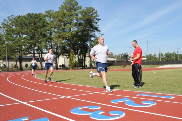 Master Sgt. Chuck Downs times Airmen?s run during a fitness improvement training session on Seymour Johnson Air Force Base, N.C., Oct. 26, 2011. Downs informing runners of their time allows them to know if they have a good pace or need to speed up. Downs is a 4th Force Support Squadron fitness center section chief and a native of Oak Hill, W.Va. (U.S. Air Force photo by Senior Airman Whitney Stanfield)   