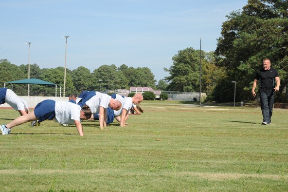 Michael Unden, 4th Force Support Squadron military fitness specialist, pushes Airmen to their limit during a fitness improvement training session on Seymour Johnson Air Force Base, N.C., Oct. 26, 2011. While Airmen workout, Unden defines to them what pain is and will tell them when they will feel it. Unden is a native of Wichita, Kan. (U.S. Air Force photo by Senior Airman Whitney Stanfield)  