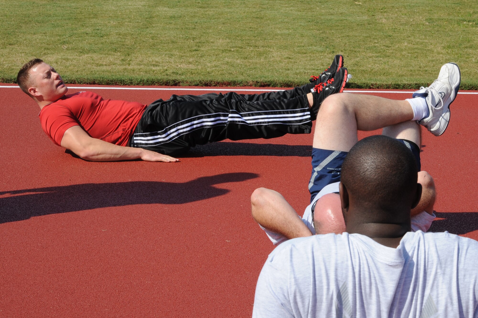 Senior Airman Jerad Perea demonstrates a leg throw-in during a fitness improvement training session on Seymour Johnson Air Force Base, N.C., Oct. 26, 2011. A throw-in is an abdominal exercise. Perea trains profiled Airmen for 45 minutes in the areas they are able to work-out. Perea is a 4th Force Support Squadron personal trainer and a native of Albuquerque, N.M. (U.S. Air Force photo by Senior Airman Whitney Stanfield)   