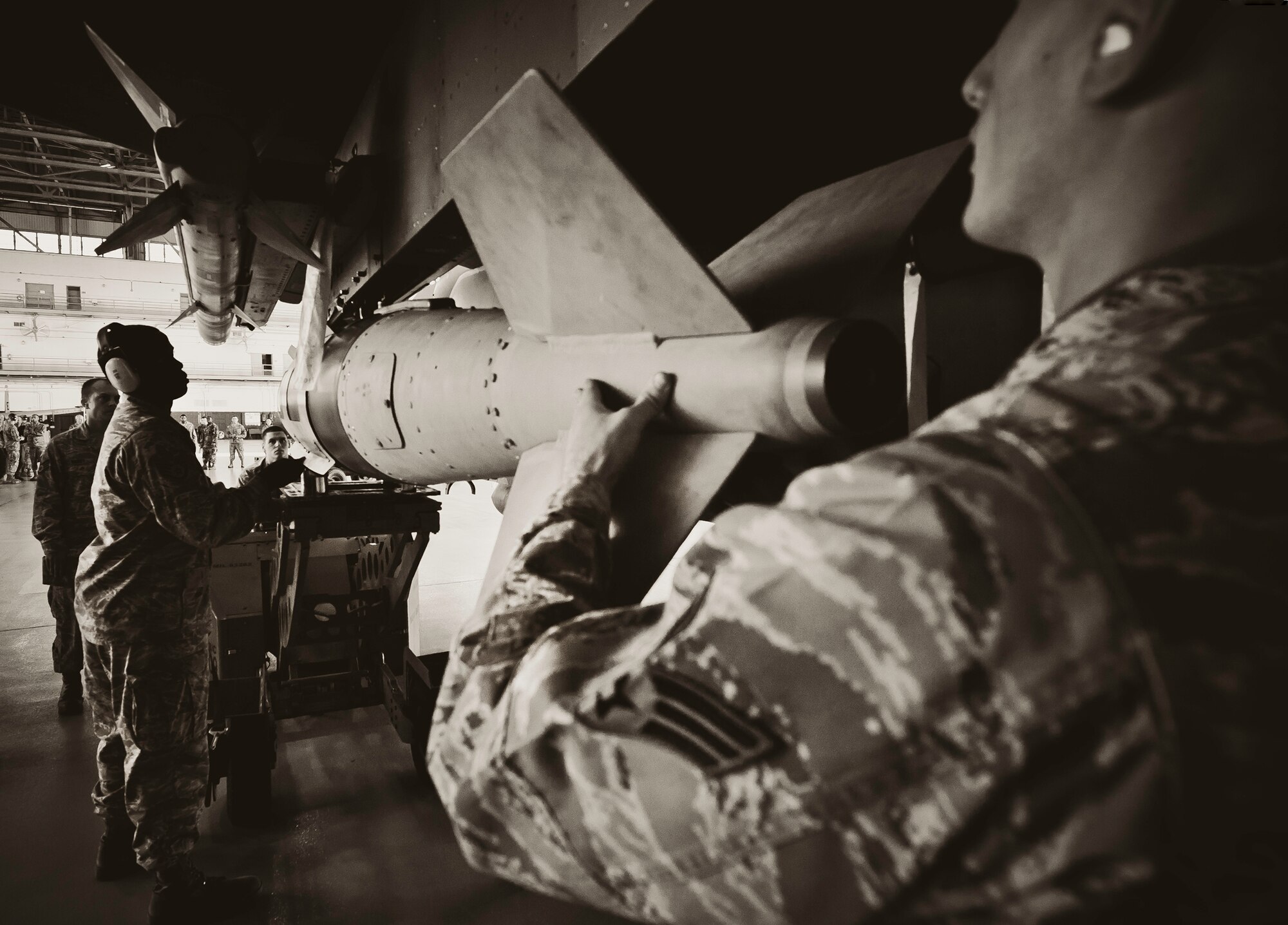Staff Sgt. Anthony Childers and Senior Airman Michael Simmers, of the 46th Aircraft Maintenance Squadron Red crew, maneuver the Joint Direct Attack Munition into place during the 46th Maintenance Group’s third quarter weapons load competition at Eglin Air Force Base, Fla., Oct. 28.  The best of the best from AMU Red and AMU Blue met to load a Joint Direct Attack Munition and an AIM-9 onto an F-15 and F-16 respectively.  AMU Red won with the best time and fewest errors.  (U.S. Air Force photo/Samuel King Jr.)