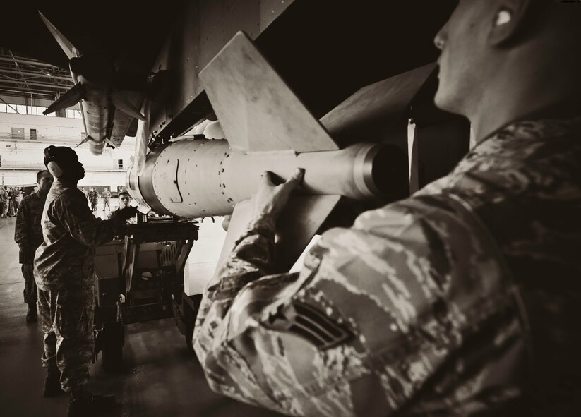 Staff Sgt. Anthony Childers and Senior Airman Michael Simmers, of the 46th Aircraft Maintenance Squadron Red crew, maneuver the Joint Direct Attack Munition into place during the 46th Maintenance Group’s third quarter weapons load competition at Eglin Air Force Base, Fla., Oct. 28.  The best of the best from AMU Red and AMU Blue met to load a Joint Direct Attack Munition and an AIM-9 onto an F-15 and F-16 respectively.  AMU Red won with the best time and fewest errors.  (U.S. Air Force photo/Samuel King Jr.)