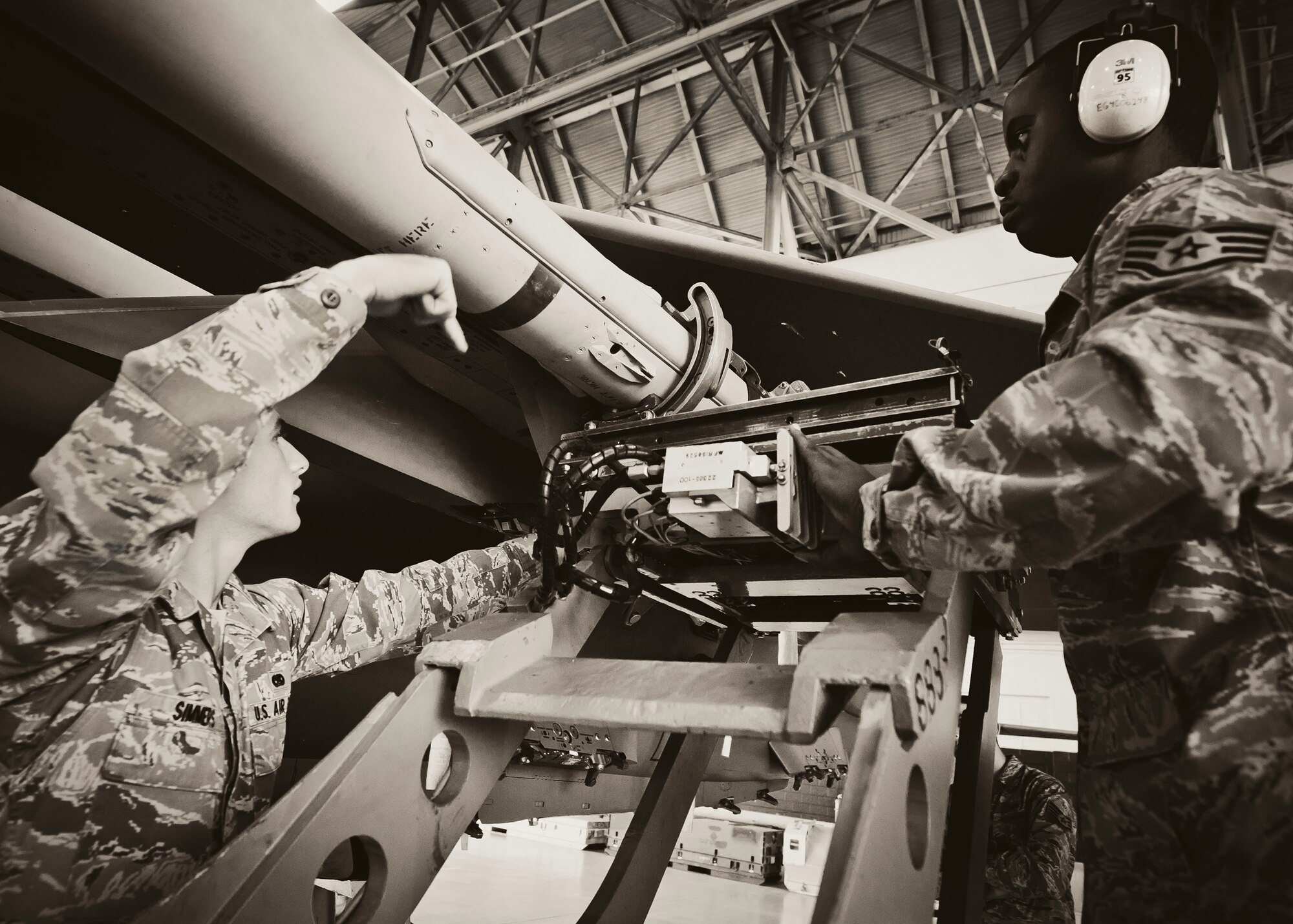 Senior Airman Michael Simmers, with the 46th Aircraft Maintenance Squadron, directs the loader to where the weapon needs to be during the 46th Maintenance Group’s third quarter weapons load competition at Eglin Air Force Base, Fla., Oct. 28.  The best of the best from AMU Red and AMU Blue met to load a Joint Direct Attack Munition and an AIM-9 onto an F-15 and F-16 respectively.  AMU Red won with the best time and fewest errors.  (U.S. Air Force photo/Samuel King Jr.)