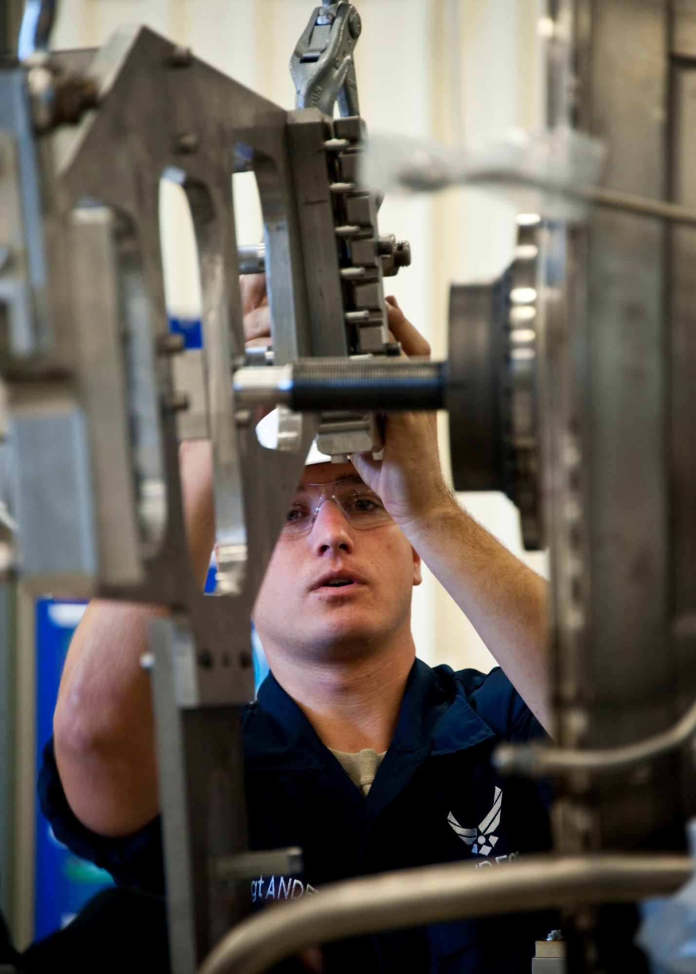 Staff Sgt. Jason Anderson, a 58th Aircraft Maintenance Squadron maintainer, guides an F-35 Lightning II joint strike fighter engine immobilizer into place at Eglin Air Force Base, Fla., Oct. 27.  Airmen, Marines and Sailors are executing step-by-step processes to validate engine maintenance procedures for the F-135 to ensure they are sound before being taught to future F-35 maintainers.  (U.S. Air Force photo/Samuel King Jr.)