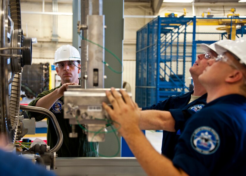 Sgt. Orazio Cara, a Marine Fighter Attack Training Squadron 501 maintainer, helps Airmen move an F-35 Lightning II joint strike fighter engine immobilizer into place at Eglin Air Force Base, Fla., Oct. 27.  Airmen, Marines and Sailors are executing step-by-step processes to validate engine maintenance procedures for the F-135 to ensure they are sound before being taught to future F-35 maintainers.  (U.S. Air Force photo/Samuel King Jr.)