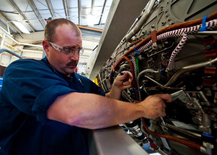 Petty Officer 1st Class Jake Bauer, a Strike Fighter Squadron 101 maintainer, makes adjustments to an F-35 Lightning II joint strike fighter engine at Eglin Air Force Base, Fla., Oct. 27.  Airmen, Marines and Sailors are executing step-by-step processes to validate engine maintenance procedures for the F-135 to ensure they are sound before being taught to future F-35 maintainers.  (U.S. Air Force photo/Samuel King Jr.)
