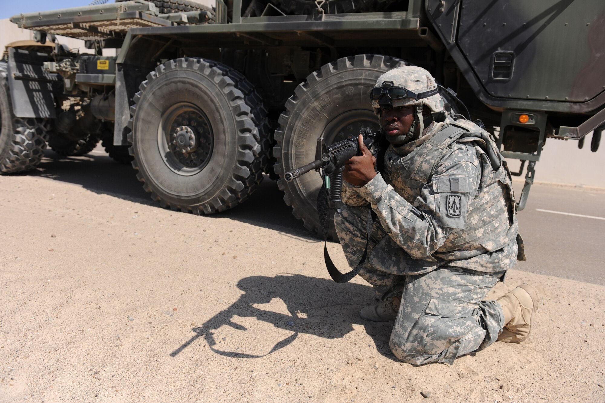 Spc. Detric Barrett, a petroleum supply specialist for the 3rd Battalion, 4th Air Defense Artillery Regiment, Charlie Battery, secures the perimeter of a vehicle during convoy training, Oct. 28, 2011, at an air base in Southwest Asia. Airmen from the 380th Expeditionary Security Forces Squadron conducted a tactical convoy training battle drill with the Soldiers of the 3-4 ADAR, Charlie Battery, which covered threat response for things like improvised explosive devices and ambushers as well as wounded-Soldier evacuations and procedures for sending reports up to appropriate channels. (U.S. Air Force photo/Master Sgt. Chance Babin)