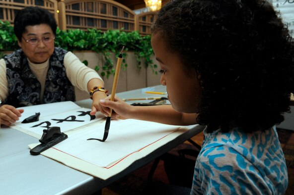 Aiyana Reeves, right, daughter of Tech. Sgt. Zoe Reeves, 35th Logistics Readiness Squadron, learns to write calligraphy during the 24th annual Japan Day, Misawa Air Base, Japan, Oct. 29. Japan Day is an opportunity for Misawa residents and their families to immerse themselves in various aspects of the Japanese culture. (U.S. Air Force photo/Tech. Sgt. Marie Brown) 
