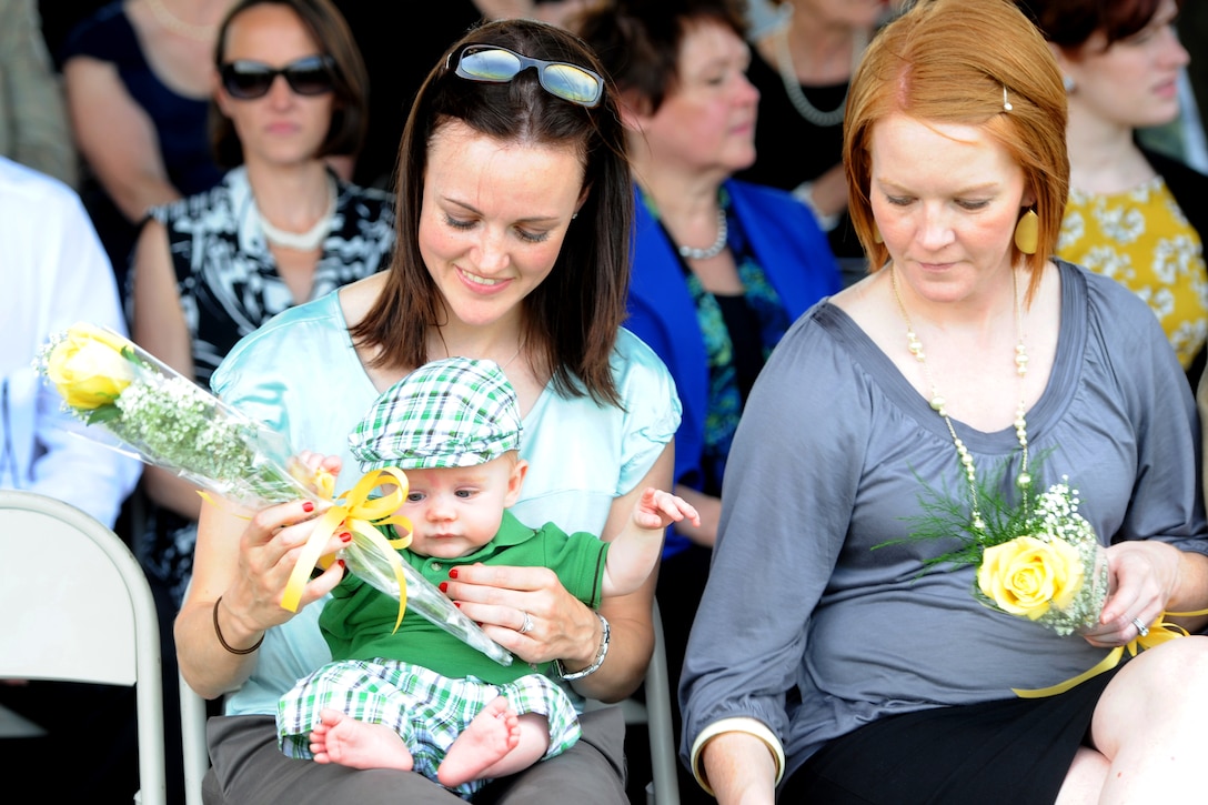 Daughters of Gen. Martin E. Dempsey, Caitlin, left, and Megan, right, and grandson Luke, hold flowers during an arrival and swearing-in ceremony for Dempsey on Fort Myer, Va., April 11, 2011. Dempsey was sworn in as the 37th Chief of Staff of the Army after Gen. George W. Casey, Jr., who had retired.

