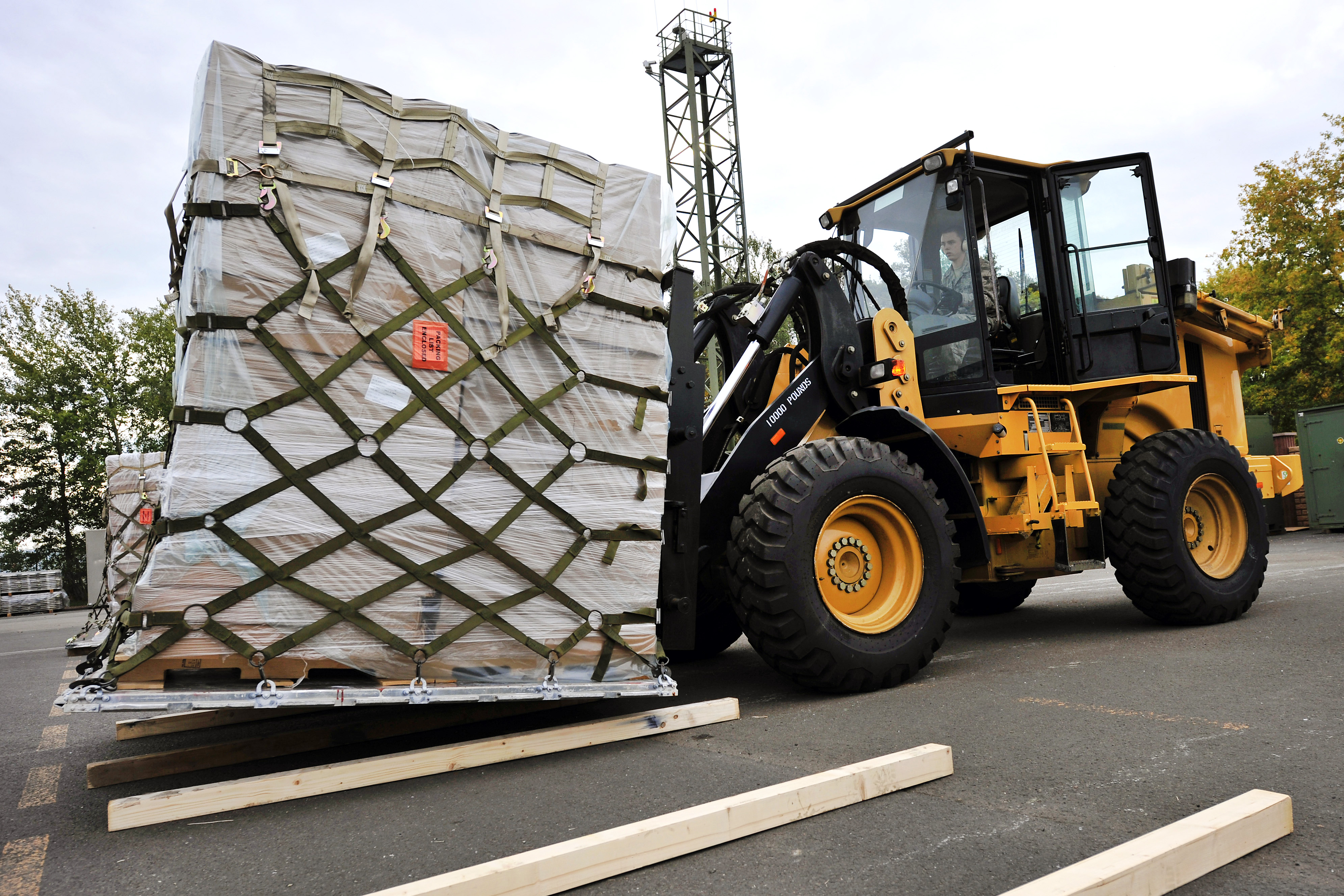 U.S. Air Force Airman 1st Class Matthew Hutchinson transports a pallet of humanitarian supplies onto a