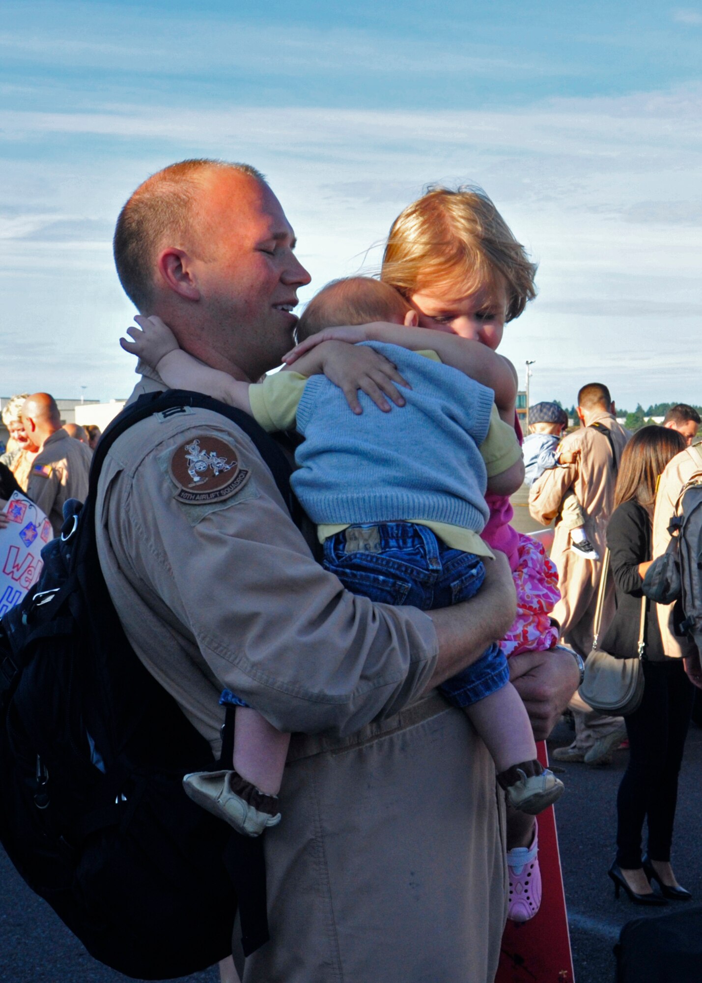 A member of the 10th Airlift Squadron hugs his kids Sept. 1, 2011, at Joint Base Lewis-McChord, Wash., during the redeployment of the 10th AS. (U.S. Air Force Photo/Staff Sgt. Frances Kriss)