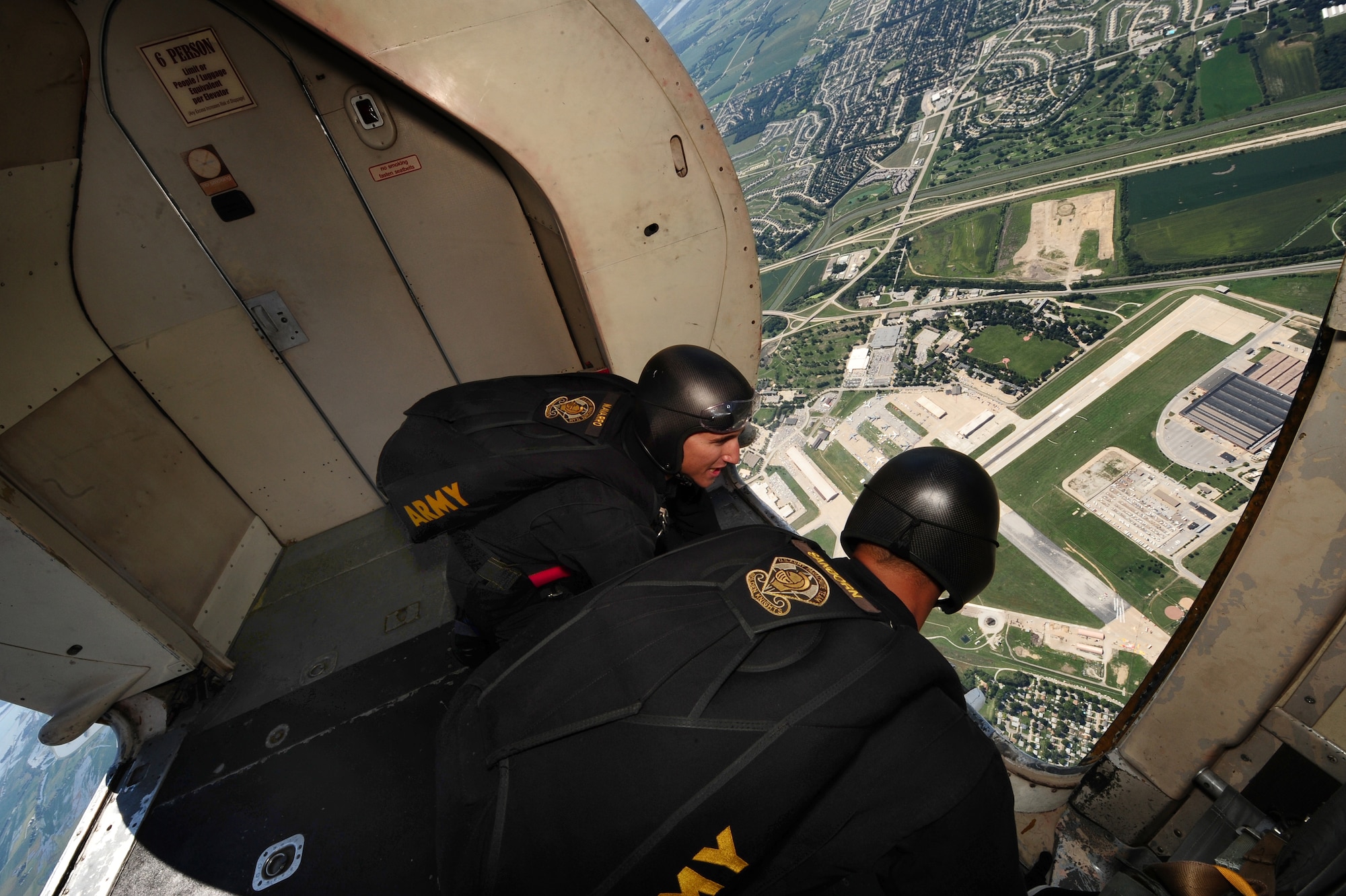 U.S. Army Spc. Mathew Navarro and Staff Sgt. Howard Sanborn, assigned to the Golden Knights demonstration team, look out over the Offutt Air Force Base, Neb., runway, from a Fokker C-31A Troopship, prior to beginning their synchronized jump for the 2011 Defenders of Freedom Open House and Air Show, Aug. 27.  The Golden Knights have been performing at air shows since its inception in1961. (U.S. Air Force photo by Josh Plueger)