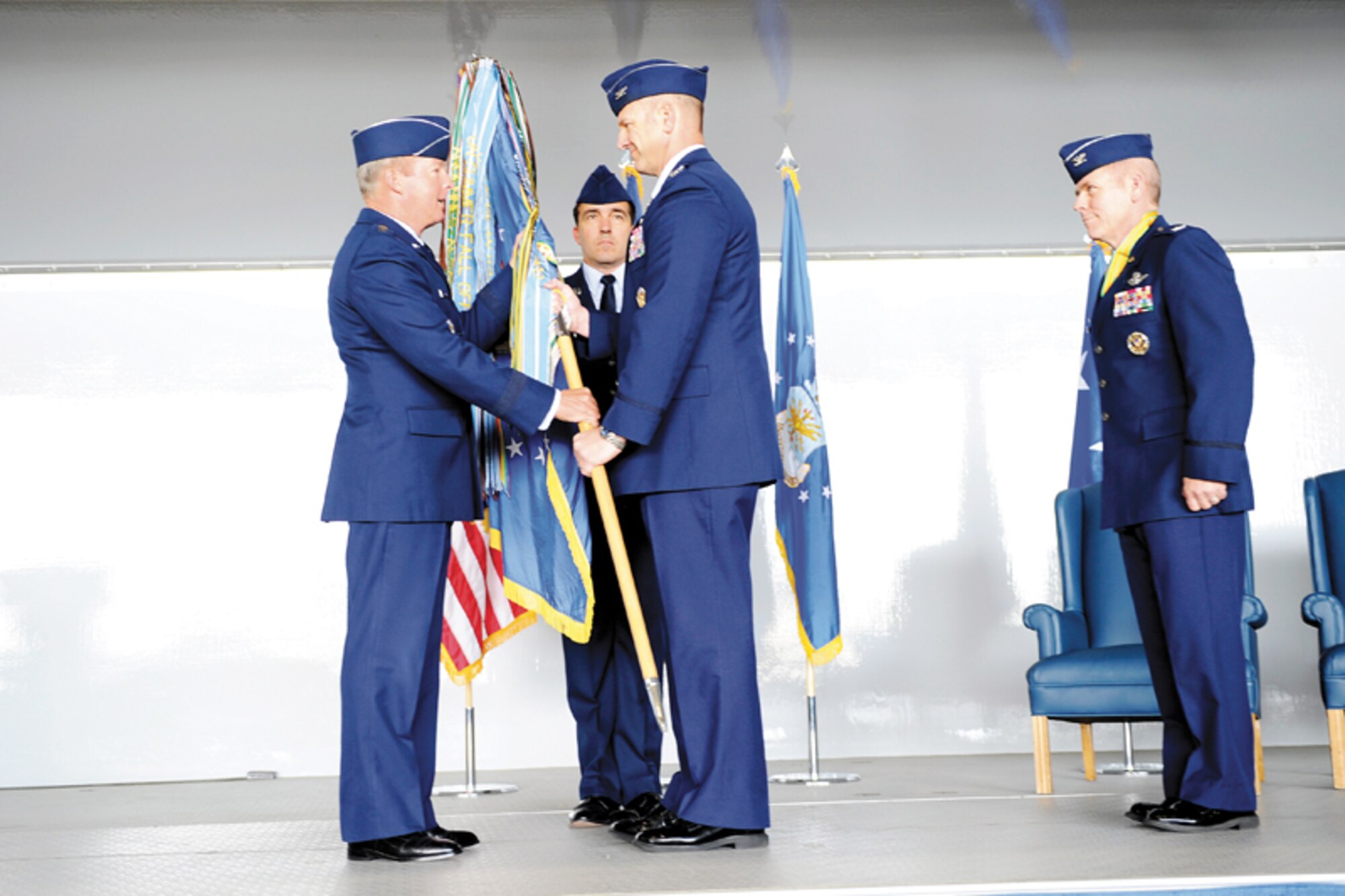 Air Force Col. Dirk Smith, 3rd Wing commander, accepts the wing’s colors from Air Force Lt. Gen. Dana T. Atkins, Alaskan Command commander, before handing the colors back to Chief Master Sgt. Steven Bohannon, while former 3rd Wing commander Air Force Col. Jack McMullen looks on. (U.S. Air Force photo/Steve White)
