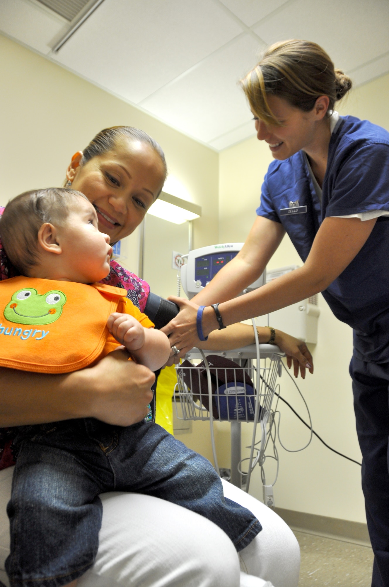 Airman 1st Class Elizabeth Zello, 60th Surgical Operations Squadron women's health medical technician, check the blood pressure of patient Maria Anthony, who is accompanied by her 4-month-old son Ryan. (U.S. Air Force photo/Staff Sgt. Timothy Boyer)
