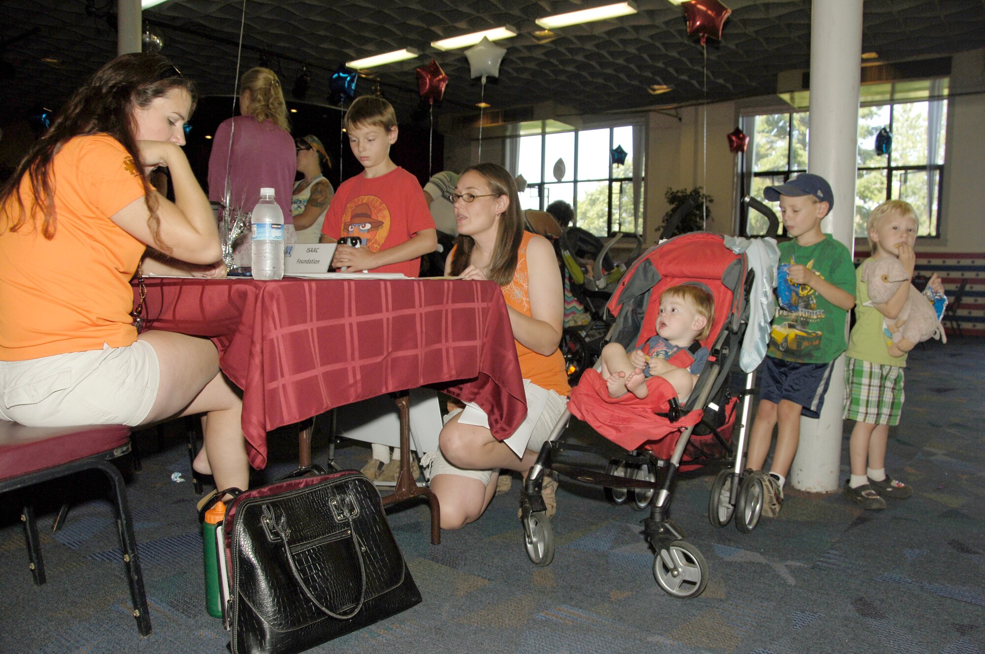 Robin Everett and her children, from left, Isaac, Wyatt, Eli and Jack attend the 3rd Annual Exceptional Family Member Program Information and Fun Fair Aug. 26 at the Deel Community Center. Everett’s husband, Tech. Sgt. Nathan Everett, 92nd Aircraft Maintenance Squadron, is currently serving at the Grant County International Airport in  Moses Lake, Wash. Holly Lytle of the ISAAC Foundation shares information about obtaining alternate therapies for Autism that currently are not covered by TriCare. More than 100 people attended the EFMP Fair and about a dozen different helping agencies, both at Fairchild Air Force Base and the Spokane community, provided information about available services. (U.S. Air Force photo/Tech. Sgt. Jennifer Buzanowski)
