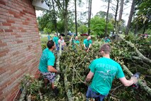 Aircrew members from the 335th Fighter Squadron assist Willie Sparks in the removal of a tree that damaged the roof of his house in the community of Goldsboro, N.C., Aug. 30, 2011. Twenty-one members from the 335th FS from Seymour Johnson Air Force Base worked much of their morning cleaning yards of four families affected by the storm. (U.S. Air Force photo by Senior Airman Rae Perry /Released)