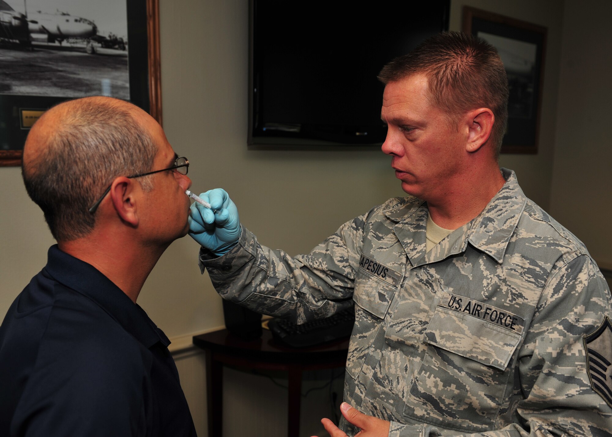 Master Sgt. Michael Capesius, 92nd Medical Operations Squadron immunizations, gives Chief Master Sgt. Rudy Lopez, 92nd Air Refueling Wing command chief his annual flu mist Aug 19.  (U.S. Air Force photo/Staff Sgt. Michael Means)