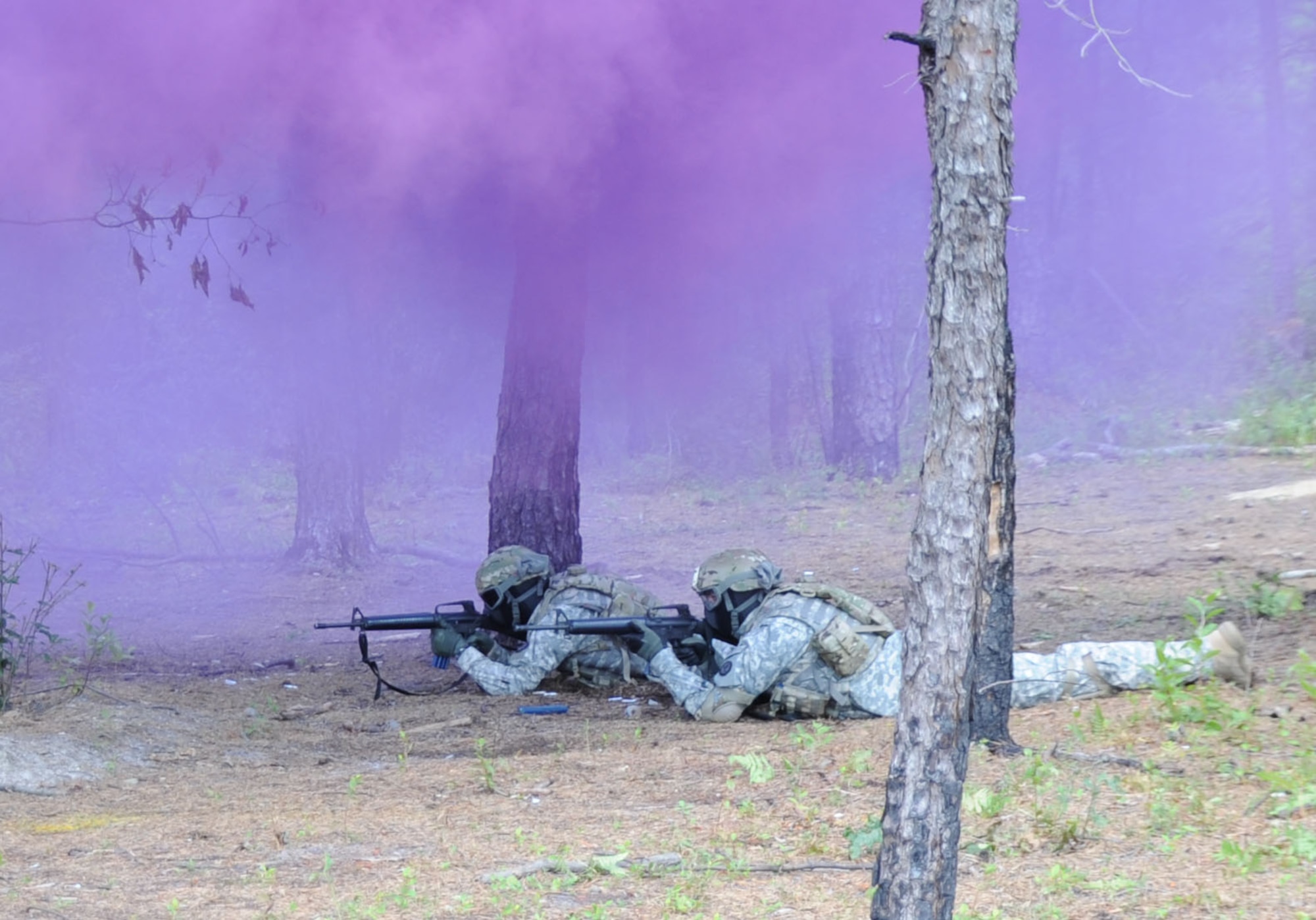 Soldiers return fire under cover of a purple smoke grenade during an ambush training scenario utilizing the Close Combat Mission Capability Kit System Aug. 23 at Joint Base McGuire-Dix-Lakehurst. The CCMCK system provides Soldiers the ability to fire 5.56mm and 9mm Man-Marking ammunitions in their assigned weapon using a non-toxic, inert, wax based compound dye-marker less-than lethal munitions. (U.S. Air Force photo by Pascual Flores/Released)