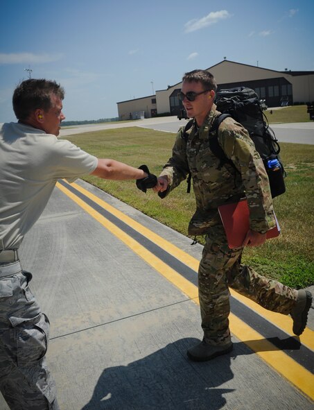 U.S. Air Force Tech. Sgt. Jerry Good, 23rd Logistics Readiness Squadron NCO in charge of air terminal operations, left, shakes the hand of a 38th Rescue Squadron member as he prepares to board a C-17 Globemaster III aircraft at Moody Air Force Base, Ga., Aug. 26, 2011. Deployment control center personnel are some of the last members from Moody to wish deploying members goodbye as they head out to their deployment. (U.S. Air Force photo by Airmen 1st Class Nicholas Benroth/Released)