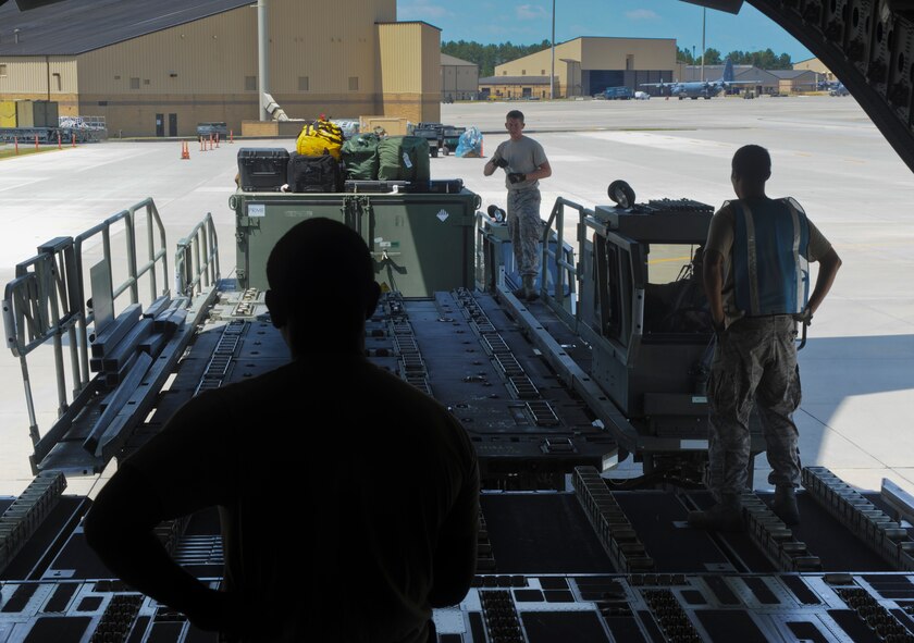 Members of the 23rd Logistics Readiness Squadron air transportation crew prepare to load a crate into the back of a C-17 Globemaster III aircraft at Moody Air Force Base, Ga., Aug. 26, 2011. The crew used rollers to slide the crates into the aircraft, which made placing and moving the gear easier. (U.S. Air Force photo by Airmen 1st Class Nicholas Benroth/Released)