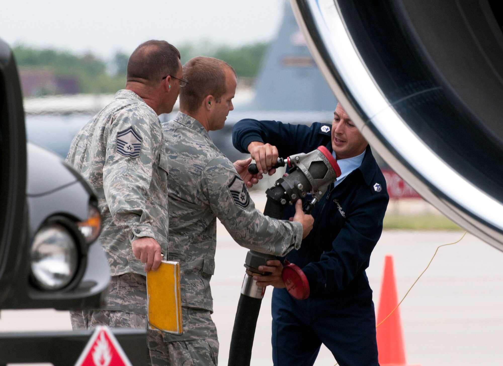 Under the wing of Air Force One at the Minneapolis-St. Paul International Airport on August 30, 2011, Senior Master Sgt. Steve Tuttle (left) and Master Sgt. Timothy Hayes of the 133rd Logistics Readiness Squadron hand the single point nozzle from the R11 refueler to the Air Force One crew chief so that he can attach it to the aircraft. Air Force One, the VC-25A which is a highly customized Boeing 747-200B, arrived at the Minnesota Air National Guard base bringing President Barack Obama, the commander-in-chief, to the Twin Cities where he delivered a speech to the American Legion Annual Conference. The visit is heavily supported with security, logistics, media and other support by the Airmen of the 133rd Airlift Wing. USAF official photo by Senior Master Sgt. Mark Moss