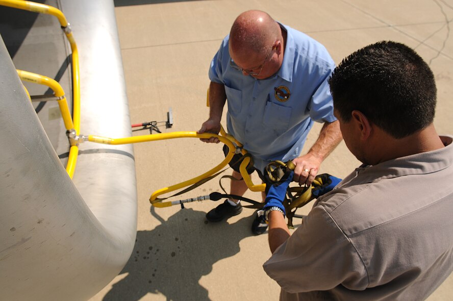 Mike Ashmore, left, and Philip Romero, Eco Wash Team members from Pratt & Whitney, Dallas, Tex., install the wash hose of an ECO System to the front of a CFM International CFM56 engine (F108 military designation) on a KC-135R Stratotanker at Scott AFB, Ill., on August 24, 2011. The hose sprays water through the engine and washes off deposits and build ups. The 126th Air Refueling Wing, Illinois Air National Guard, is participating in the engine wash as a fuel conservation measure. Washing the engine is expected to reduce the Exhaust Gas Temperature (EGT) margin by 5-6 degrees resulting in fuel savings and longer engine life. (U.S. AF photo by Master Sgt. Ken Stephens) (Released)