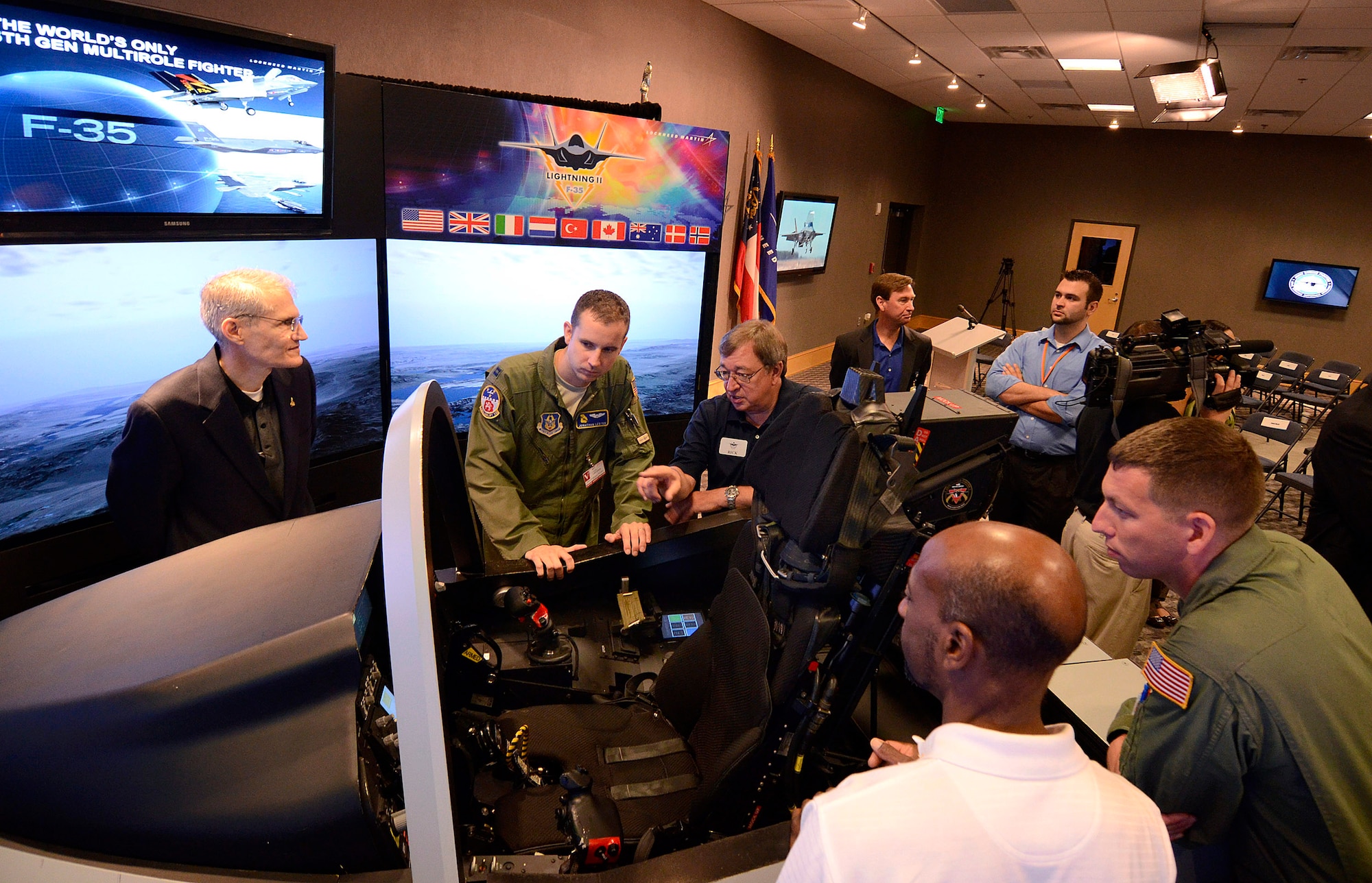 Representatives from Lockheed Martin explain the F-35 Joint Strike Fighter cockpit demonstrator to Capt. Jonathan Lester, a C-130 pilot, and Senior Airman Michael Sterchi, a C-130 Loadmaster, both from the 700th Airlift Squadron at Dobbins Air Reserve Base, 31 Aug.  Lockheed Martin held a special event for the press and invited guests at the Marietta facility with their F-35 Joint Strike Fighter cockpit demonstrator as the focal point.  (U.S. Air Force photo/ Brad Fallin)