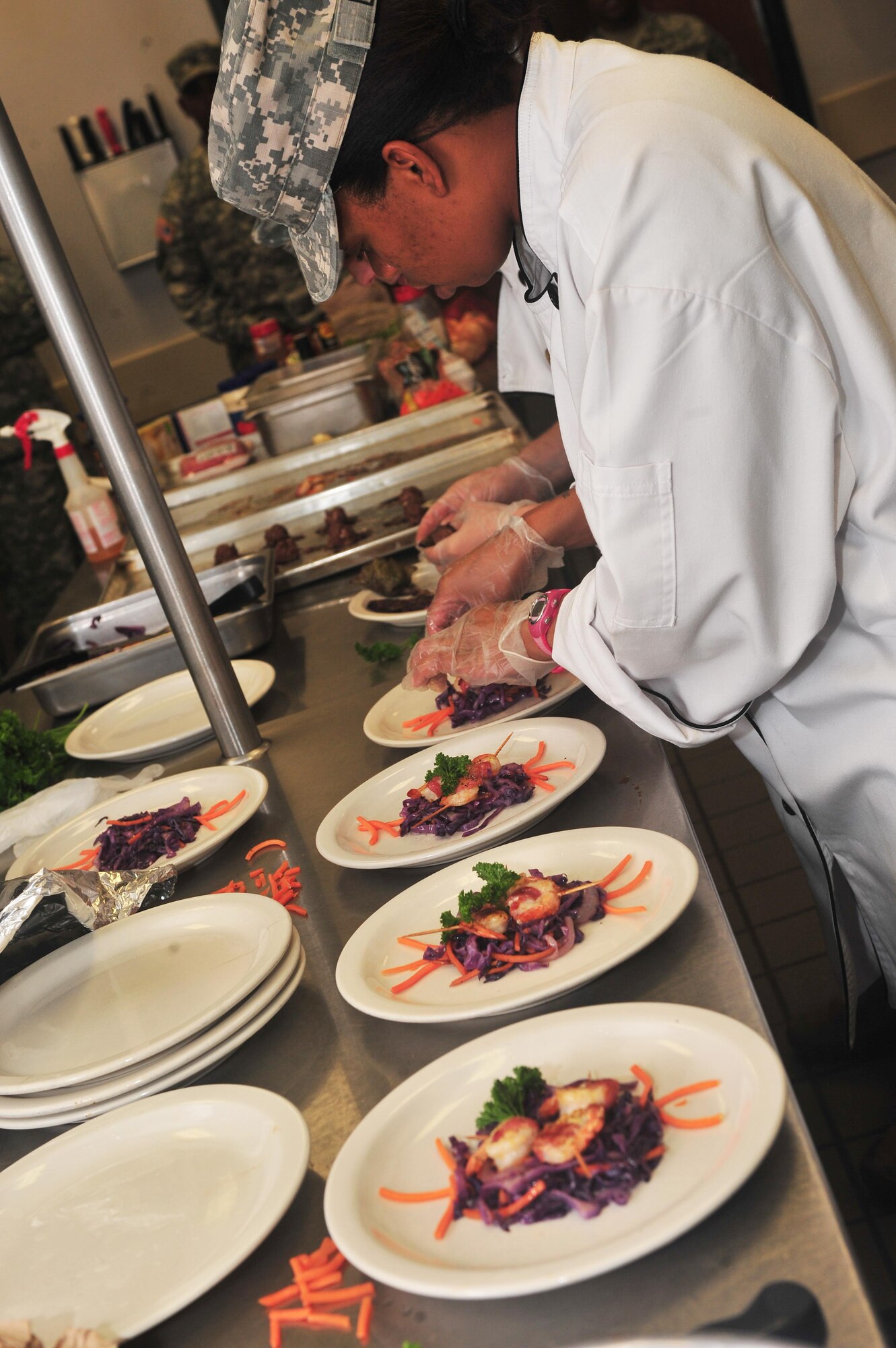 U.S. Army Spc. Debra Looney, 3rd Army food specialist, adds the final 
touches to her dish during the Iron Chef Competition at Shaw Air Force Base, S.C. 
Aug. 31, 2011. The teams were tasked to produce one entre and one appetizer 
using what was provided in the kitchen and the surprise ingredient of red 
cabbage. The products were judged on the categories of taste, presentation, 
creativity and incorporation of the special ingredient. (U.S. Air Force photo 
by Airman 1st Class Ashley Gardner)