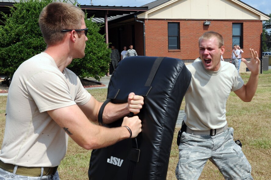 U.S. Air Force Staff Sgt. Matthew Powell, 23rd Security Forces Squadron (SFS) unit trainer, left, holds a defensive fighting position as Senior Airman Jeremy Vess, 23rd SFS visitor control center, practices defensive movements after being sprayed with pepper spray for training at Moody Air Force Base, Ga., Aug. 31, 2011. This was the first time the unit used pepper spray during training. (U.S. Air Force photo by Senior Airman Ciara Wymbs/Released)