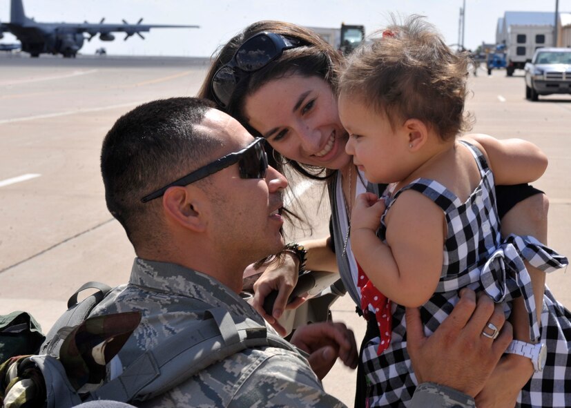Cassandra and Madeline Ortega, greet Tech. Sgt. Julius Ortega, 27th Special Operations Aircraft Maintenance Squadron, at his return from deployment, at Cannon Air Force Base, N.M., Aug. 31, 2011. Returning Air Commando?s were greeted by their loved ones at the redeployment line, that is held on the flight line for their convenience. . (U.S. Air Force photo by Airman 1st Class Ericka Engblom)