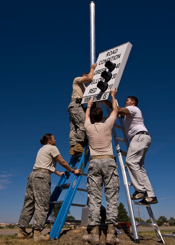 Members of the 28th Security Forces Squadron Logistics and Resources Section assemble the first of six new road condition signs on Ellsworth Air Force Base, S.D., Aug. 31, 2011. The signs are controlled wirelessly, and display the current road conditions and speed limit, which allow drivers to adjust their speed and driving practices to help make the road a safer place. (U.S. Air Force photo/Airman 1st Class Kate Thornton/Released)