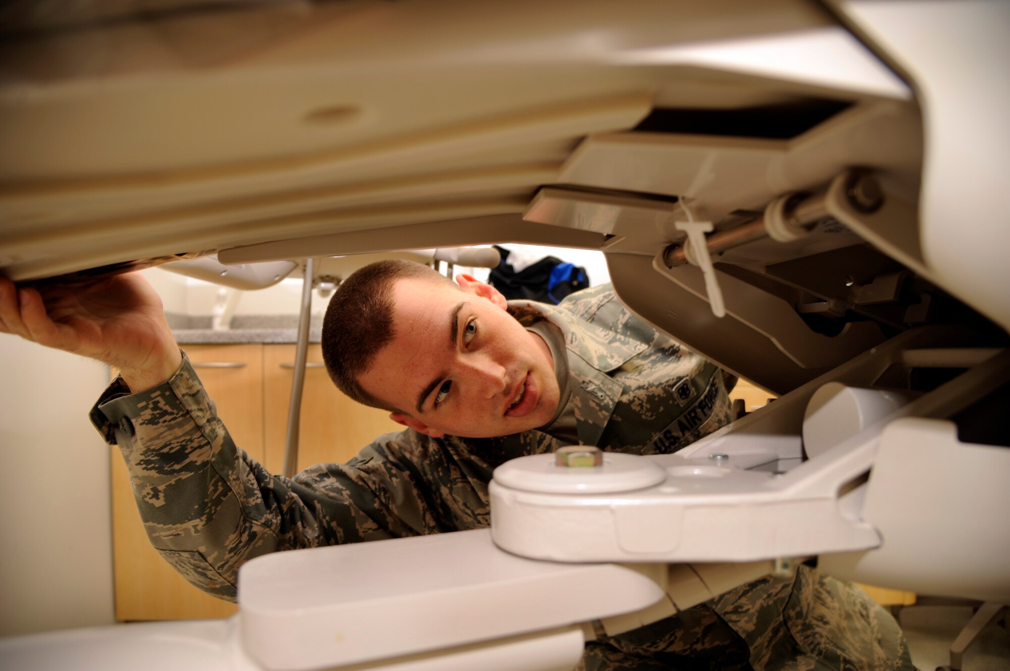 WHITEMAN AIR FORCE BASE, Mo.- Staff Sgt. David McCann, Medical Support Squadron medical maintenance technician, inspects a dental chair at the base clinic Aug. 26 to see if the back retention sensor is defective. If so, McCann will replace the sensor with a new one and reconnect the wiring throughout the dental chair. Medical maintenance has the crucial job of ensuring all medical machinery is serviceable, so the base clinic here can safely treat its monthly average of 5,000 patients.  (U.S. Air Force photo/Senior Airman Cody H. Ramirez)