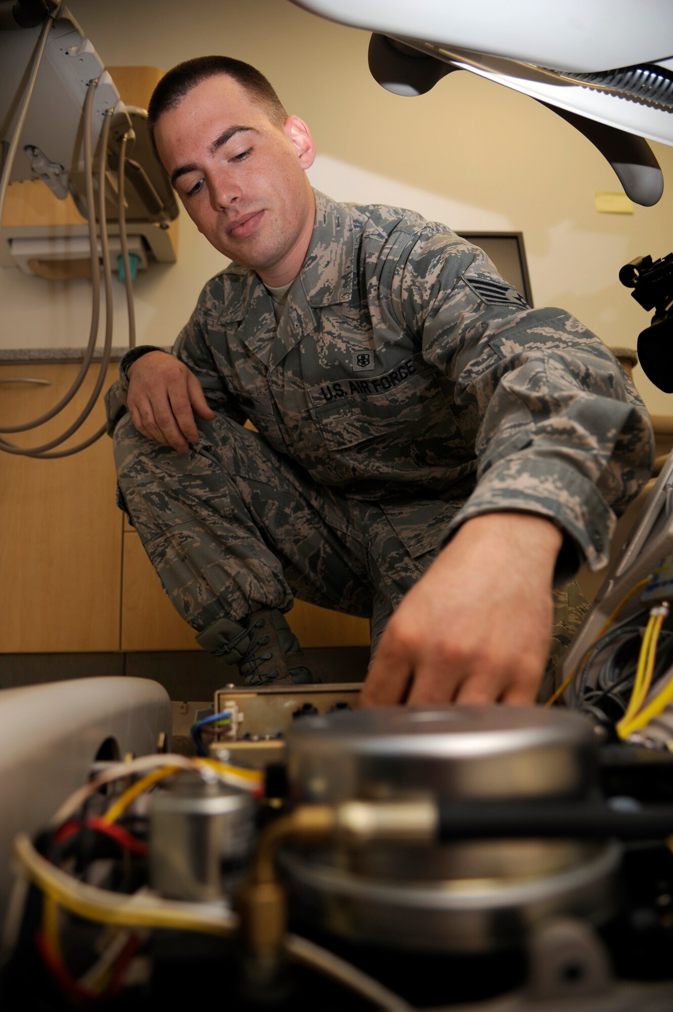 WHITEMAN AIR FORCE BASE, Mo.- Staff Sgt. David McCann, Medical Support Squadron medical maintenance technician, inspects wiring in a dental chair Aug. 26, at the base clinic. Medical maintenance has the crucial job of ensuring all medical machinery is serviceable, so the base clinic here can safely treat its monthly average of 5,000 patients. (U.S. Air Force photo/Senior Airman Cody H. Ramirez)