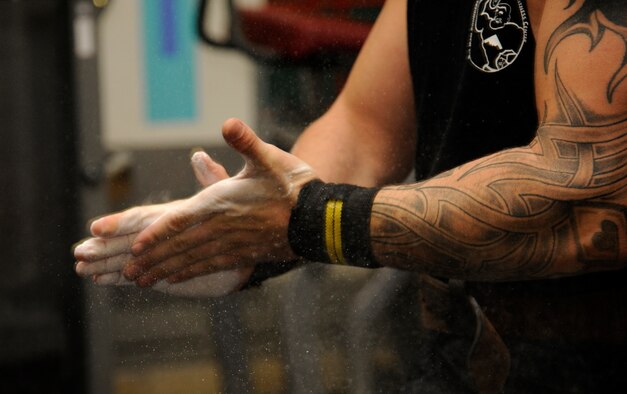 WHITEMAN AIR FORCE BASE, Mo. - Army Sergeant Stephen Kirkbride, Missouri National Guard, 1-135th Aviation Reconnaissance Battalion, chalks his hands before dead lifting at the fitness center, Aug. 22.  Kirkbride broke the 2011 Missouri State Fair Amateur Dead-lift Competition with a 550-pound lift, shattering the previous record of 515 pounds. (U.S. Air Force photo/Senior Airman Cody H. Ramirez)
